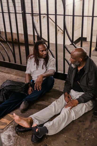 Two men, who are struggling with poverty, sat together. National and international leaders and institutions promote speeches and actions in favour of poverty
