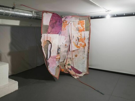 Eric Mack, Pain After Heat, 2013, rope, paper, acrylic paint, dye, ink, dried orange peel, wood, plastic, magazine image and gromets on a quilted moving blanket, 77 x 90 x 49 inches