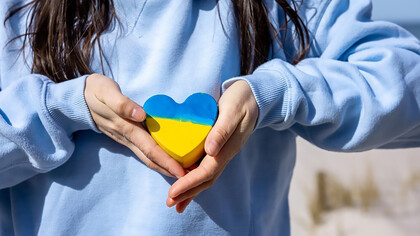 Closeup heart in the color of the flag of ukraine in female hands