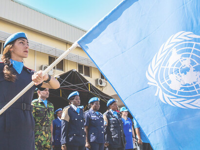 Miembros de las Fuerzas de paz (Cascos Azules) de las Naciones Unidas en formación y con la bandera oficial de la organización