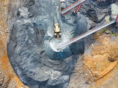 A yellow excavator is working on a uranium mine