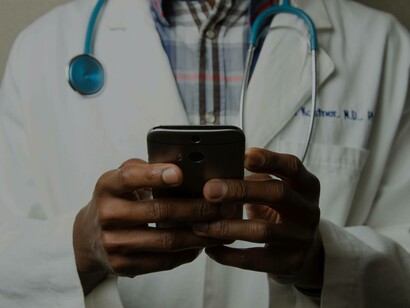 A doctor checking out the lab results of their patient on his phone and finding out that they have co-infections