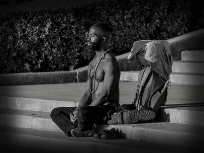 Un hombre se sienta en los escalones en estado meditativo