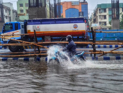 A man riding a motorcycle through a flooded street