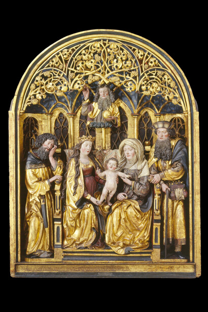 Retable représentant sainte Anne trinitaire
C’est à partir du XIIIe siècle que font leur apparition les représentations de sainte Anne, la mère de Marie. Sur le retable, l’enfant Jésus est délicatement soutenu par Marie et Anne. La scène se déroule dans une pièce en forme de chapelle aux fenêtres ogivales à remplages, dont l’architecture est typique du gothique tardif. Dépôt de la Fondation Gottfried Keller, Office fédéral de la culture, Berne.

Copyright: Musée national suisse
