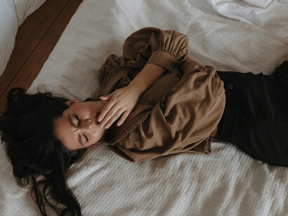 A person smiling while lying in bed, reflecting on identity, self-discovery, personal truth, and emotional honesty