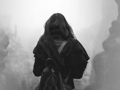 Figura de mujer caminando por un camino rocoso