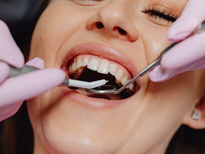 A little girl brushing her teeth, suffering from hypodontia