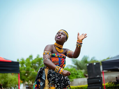 In the vibrant cultural tapestry of Accra, Ghana, a woman adorned in traditional dress moves gracefully to the rhythmic beats, her dance embodying the rich heritage of the local tribes, creating a captivating scene that celebrates the diversity and vitality of the city's cultural identity