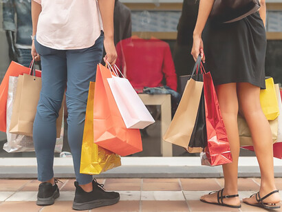 Woman and man walking around holding shopping bags