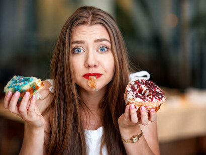 Young woman reaching for a snack late at night, representing late-night eating habits and hunger cravings