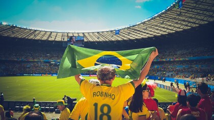 Torcedor levanta a bandeira do Brasil no estádio do Maracanã no Rio de Janeiro enquanto veste a camisa do jogador Robinho