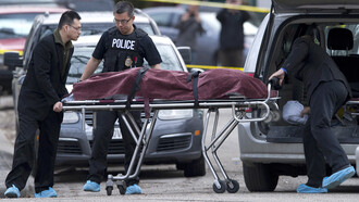 Police remove a body from the scene of a multiple fatal stabbing in northwest Calgary