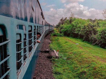 Ragazzo indiano si sporge dal finestrino in un treno in corsa, india