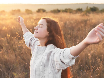 Amidst barren surroundings, a woman's open-handed prayer reflects the essence of selflessness and grace