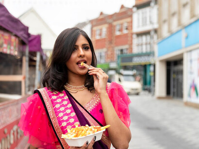 An Indian woman showcases a vibrant spread of delicious food, celebrating the rich culinary heritage and diversity of Indian cuisine