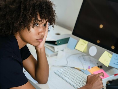 Mulher sobrecarregada de trabalho. A base para a prevenção do Burnout reside na criação de um ambiente de trabalho saudável e equilibrado. É essencial que as empresas incentivem um equilíbrio saudável entre a vida profissional e pessoal dos colaboradores

