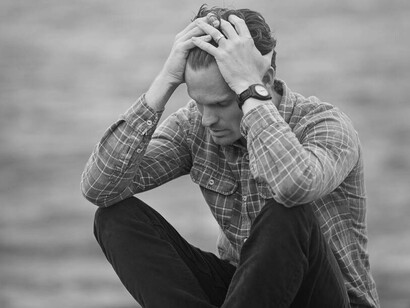 A man running his hands through his hair slowing accepting his failure