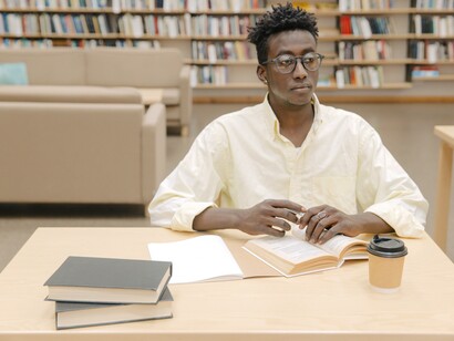 Aluno estuda com livros em biblioteca