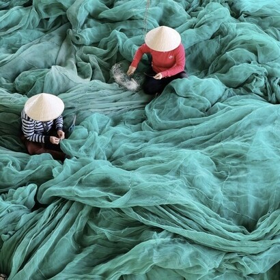  Vietnam, deux personnes sont assises sur un grand filet vert
