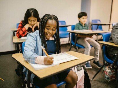 Young girl gleefully writing in her journal