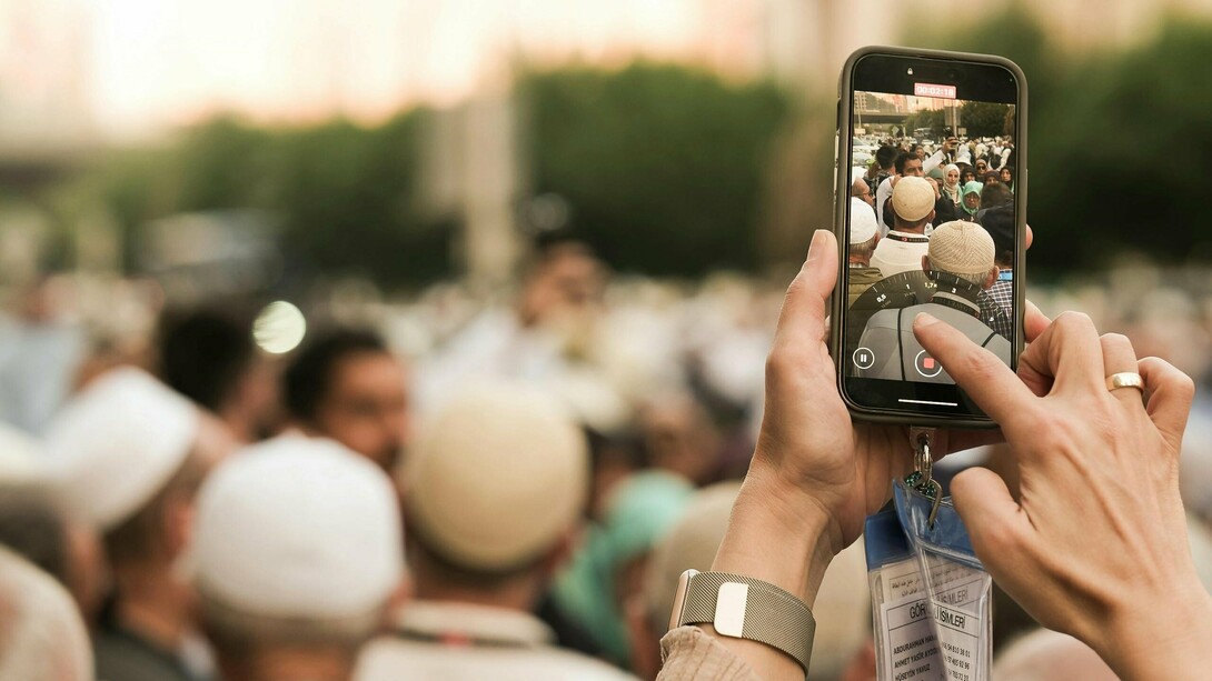 An individual capturing a live protest on their phone, reflecting the power of citizen journalism