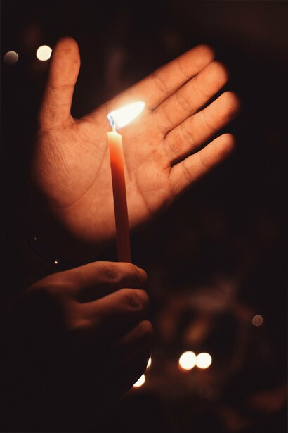 Man holding candle with hand on top