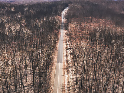 The far-reaching consequences of nature wildfires through a compelling aerial view capturing the aftermath of wildfire damage, shedding light on the interplay with climate change and the prevailing climate crisis, emphasizing the urgency for increased environmental awareness and proactive solutions