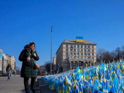 Una mujer busca la bandera que representa a su hijo en el memorial para las víctimas de la guerra en Ucrania instalado con motivo de su primer aniversario
