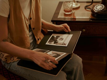 A woman turns the pages to a photo album
