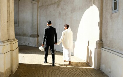 A newly married couple walking hand in hand into the light, representing the beginning of a lifelong partnership built on commitment