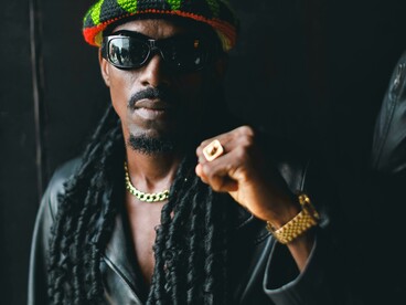 Portrait of a man in sunglasses and a hat, reflecting a traditional reggae look