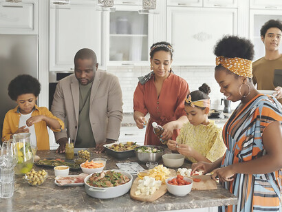 A family prepares a meal together in the kitchen