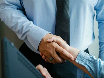 Two diverse individuals shaking hands after a peacebuilding meeting
