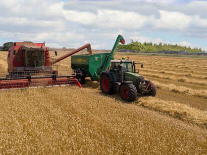 Amidst the rustic brown expanse of a field, you'll find vibrant green farming equipment, Hohenberg-Krusemark, Germany 