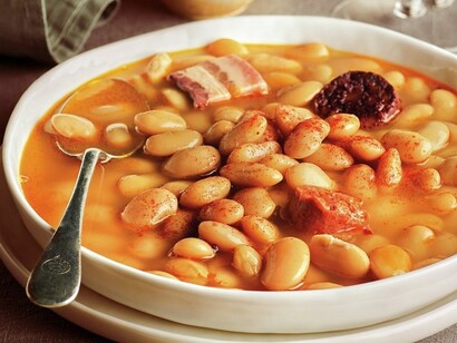 La fabada asturiana è un piatto tradizionale delle Asturie, preparato con fagioli bianchi (fabes), chorizo, morcilla e pancetta, noto per il suo sapore ricco e sostanzioso, ideale per le fredde giornate invernali del nord della Spagna.