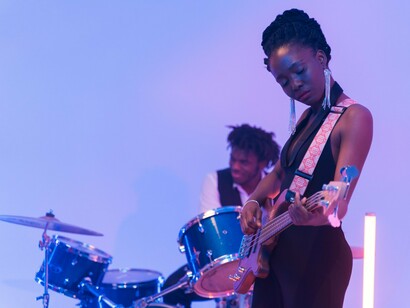 A talented Black musician performing with passion under the stage lights, representing the influence of Black creativity on music and culture
