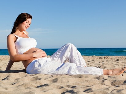 Una mujer embarazada tomando el sol en la playa