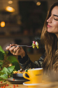 Mulher apreciando comida. Além de alimentar o corpo, a comida também promove o senso de pertencimento