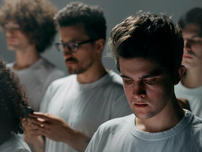 Grupo de pessoas. A saudade é um sentimento ambivalente; ao mesmo tempo em que é uma expressão de amor e conexão com a terra natal, pode também ser um fardo que pesa sobre a saúde mental. A psicanálise pode oferecer um espaço de reflexão sobre essa ambivalência. Através da escuta atenta, o psicólogo pode ajudar o migrante a explorar sua saudade, transformando-a de um peso em uma oportunidade de ressignificação