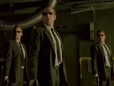 Multiple agents standing together in perfect formation, representing conformity and control in The Matrix sequels