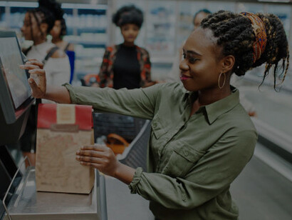 A woman buys groceries inside a cashierless store using automated checkout technology