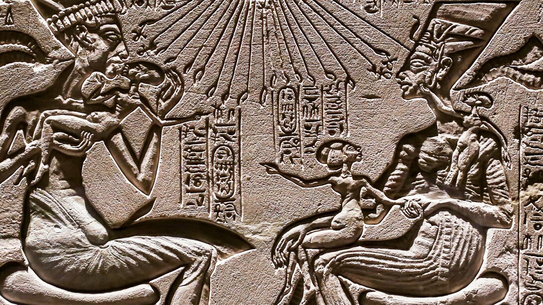 Akhenaten and Nefertiti seated, holding three of their daughters, under the rays of the sun god Aton