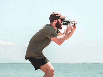 Joven cineasta grabando tomas en la playa