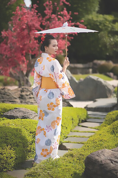 The richness of Japanese culture as a woman elegantly showcases tradition in a vibrant kimono while holding a traditional Wagasa umbrella