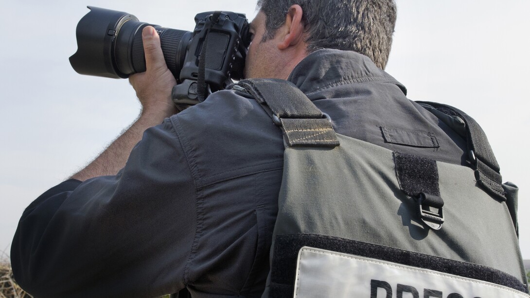 Un reportero gráfico tomando una foto con su cámara