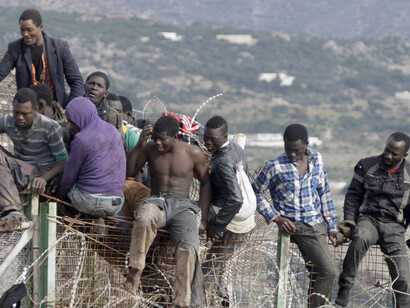 Inmigrantes africanos encaramados a la valla de Melilla