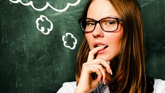 Una profesora pensativa junto a la pizarra