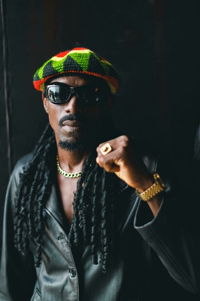 Portrait of a man in sunglasses and a hat, reflecting a traditional reggae look