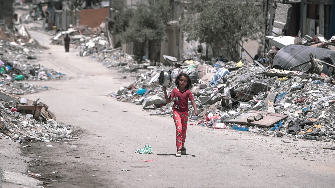 Una niña camina por las calles de la destruida Gaza en busca de comida